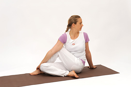 <b>HALF SPINAL TWIST (ARDHA MATSYENDRASANA)</b> – This posture helps to keep the spine elastic by retaining it’s side-to-side mobility. The roots of the spinal nerves and the sympathetic nervous system are toned and given a fresh supply of blood. Abdominal muscles are massaged, this helps to release toxins in the digestive system.